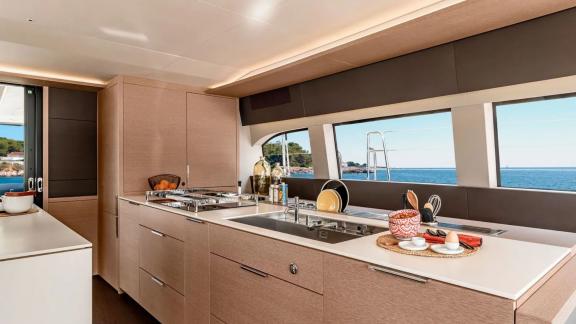 Stylish kitchen with stove, sink, and large windows with sea view on the catamaran Amada Mia