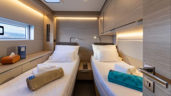 A calm and bright space with twin beds and modern touches aboard the stylish yacht Artisan.