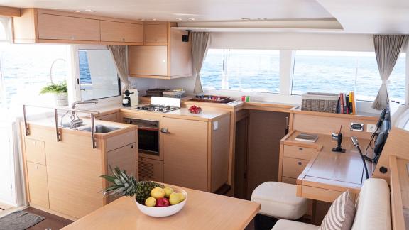 The kitchen of the Balok catamaran features a spacious countertop, an oven, and windows with a sea view.