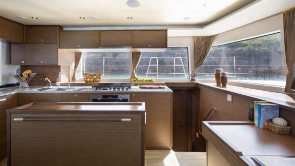 The well-equipped kitchen of the Lagoon 560 in Athens features a spacious countertop and views of the sea through large 