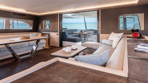 The luxurious salon of the Catamaran Daiquiri opens up to a stylish outdoor terrace, offering stunning views of the sea.