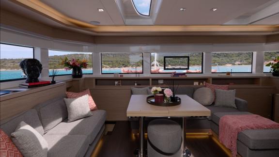 The interior salon of Dream catamaran features large windows, cozy seating areas and elegant décor with sea views.