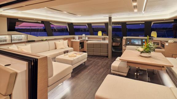 Eleganter Salon auf der Yacht Elly mit stilvollem Interieur und Blick auf das Meer bei Sonnenuntergang.