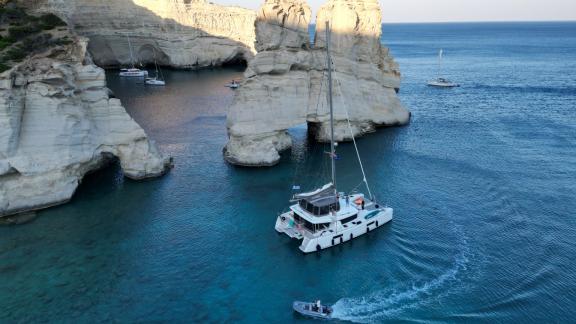 Der Katamaran Elvira 52 genießt das ruhige Wasser in einer felsigen Bucht.