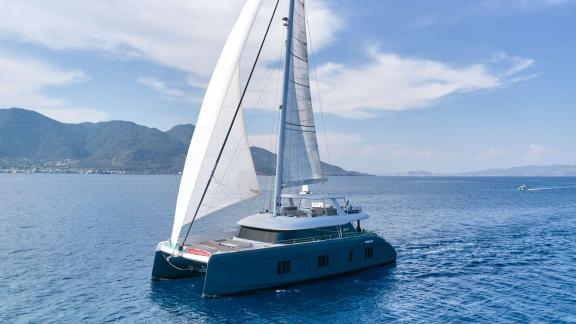 Elegant Sunreef Catamaran Genny sailing on calm waters off the coast of Athens, accommodating up to 10 people.