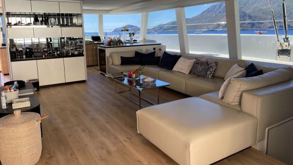 Modern salon in the Genny catamaran, featuring comfortable sofas and large windows offering expansive sea views.