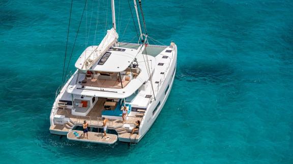 Aft deck of Catamaran Happy with a cozy seating area and swim platform for sea fun.