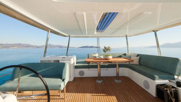 Die Flybridge der Happy bietet eine gemütliche Sitzecke mit Esstisch und Panoramablick auf das Meer.