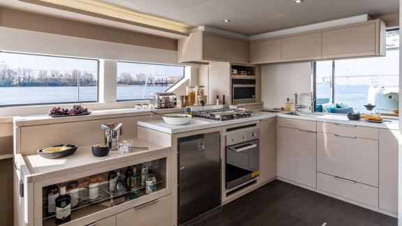 The modern kitchen of catamaran Happy with large windows and full equipment ensures comfortable meal preparation.