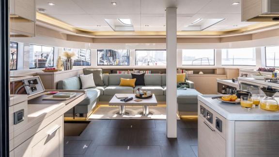 The saloon of catamaran Happy offers a spacious living area, kitchen, and bright atmosphere for comfort.