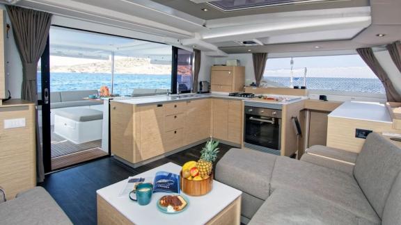 Helidoni charter catamaran features open kitchen and cozy saloon with sea view.