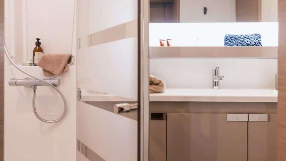 Kebisiks catamaran’s bathroom features a shower, illuminated mirror, and sleek finishes.