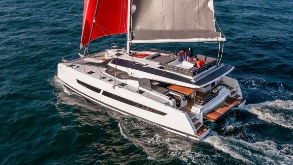 The catamaran Kebisiks sails as guests relax on the flybridge off the coast of Athens.