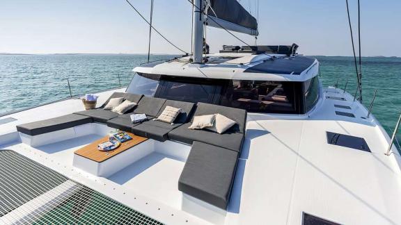The catamaran Kebisiks offers cushioned loungers and a table up front near Athens.
