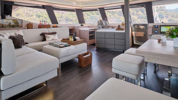 Stylishly furnished salon aboard the catamaran with modern furniture and panoramic coastal views.