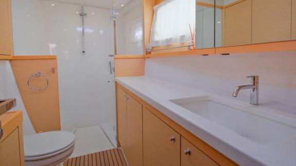 Modernes Badezimmer mit breitem Waschbecken und Glasdusche.