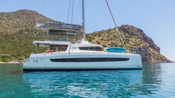Der Katamaran Libra liegt bei Athen vor Anker und bietet Segelurlaub mit Naturblick.