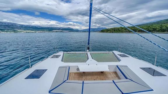 Luna 49 Blue katamaranın ön güvertesi ağ detayı, minderli alanı ve doğa manzarasıyla huzurlu bir keyif sunuyor.