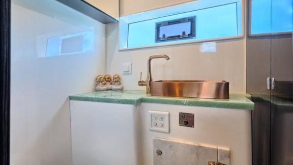 Стильная ванная комната с окном и современной раковиной создаёт комфортную атмосферу на яхте.