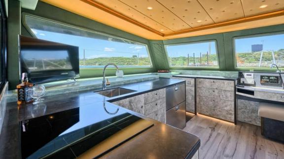 Современная кухня на катамаране Luna 49 Gold оснащена техникой и окном с видом на побережье.