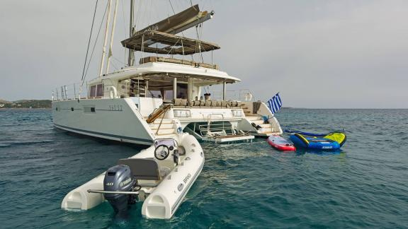 The Lagoon 560 S2 Meliti with various watersports equipment and a dinghy on the water