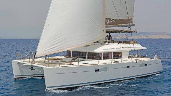 The Lagoon 560 S2 Meliti with full sails on calm, blue waters