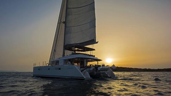 The Lagoon 560 S2 Meliti sails into the sunset, with the sea bathed in golden light