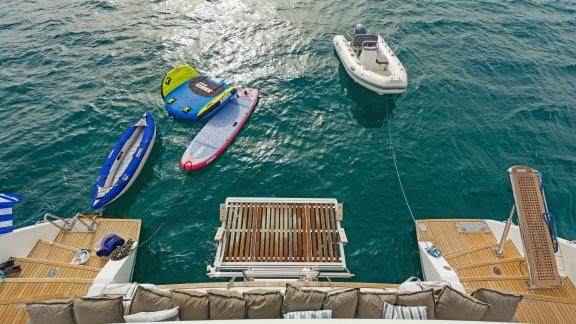 Aerial view of watersports gear and a dinghy floating behind the Lagoon 560 S2 Meliti