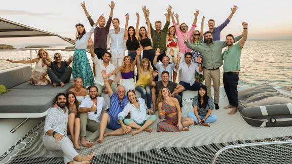 Large group of friends celebrating a joyful day tour on catamaran Alimos in Athens.