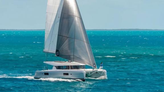 The Lagoon 42 catamaran sails majestically on the open sea in Fethiye, Turkey. Perfect for adventure seekers.