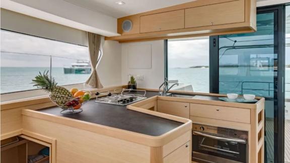 The well-equipped kitchen of the Lagoon 42 catamaran offers comfort and a beautiful view of the sea.