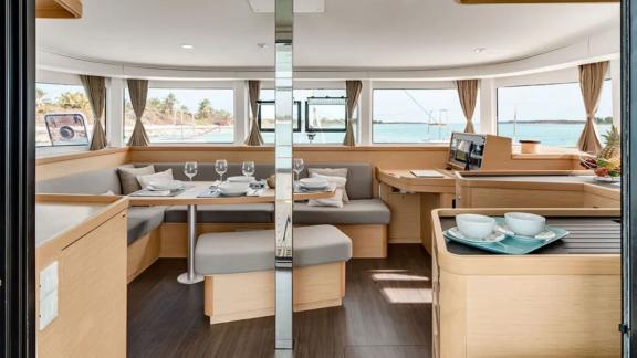 The Lagoon 42 catamaran offers a modern dining area with panoramic sea views, perfect for relaxation.