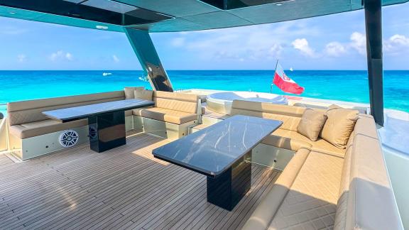 The flybridge lounge aboard Over the Moon offers a luxury charter setting with turquoise sea views off Split.