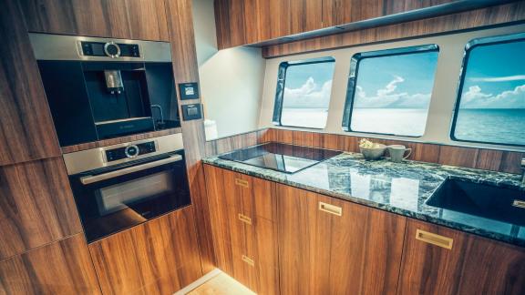 The sleek wood-finished kitchen offers a bright and modern culinary space aboard this charter yacht in Split.