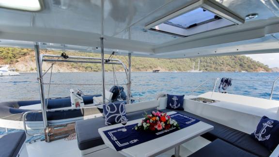 The aft deck of the catamaran Pata offers a comfortable seating area with a sea view.