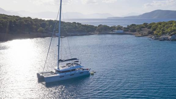 Lagoon 620 katamaranı, doğa ile çevrili Yunan adasında sakin bir koyda demirlemiş durumda.