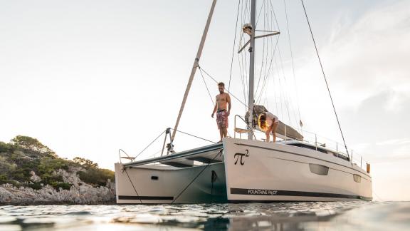 Two people enjoying the serene atmosphere on a catamaran off the coast of Greece.