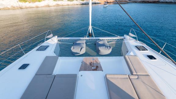 Two comfortable loungers on the net of the catamaran Pi 2 in Athens overlooking the calm sea.