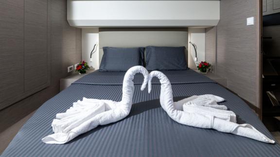 Unter den Katamaran Charter Optionen in Lefkada zeigt Premium Kabine mit Bett und dekorativen Details.