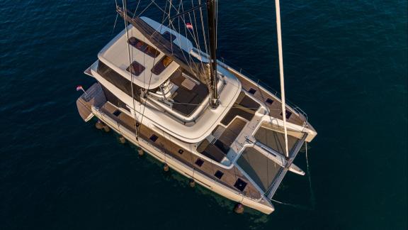 Among catamaran rental options in Kastela Princess Karla is seen from above anchored in calm sea.