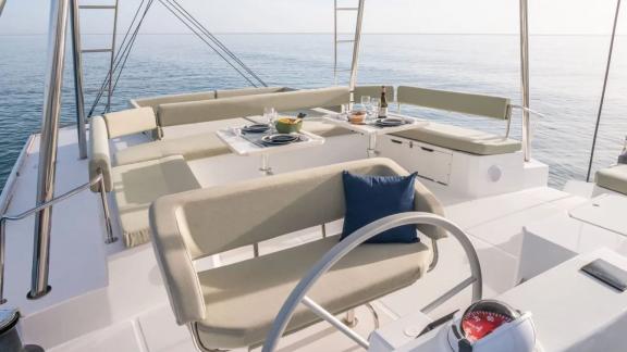 Comfortable lounging area and dining table on the upper deck of the Sahana catamaran.