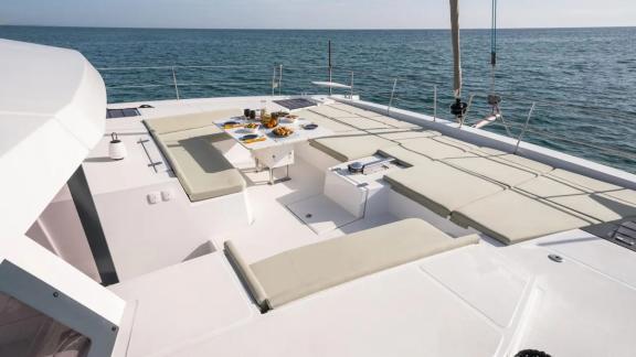 Comfortable lounging area with cushions and snacks on the foredeck of the Sahana catamaran.