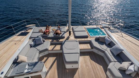Fountaine Pajot 80 Serenissima III features a foredeck jacuzzi, sun pads and comfortable lounge seating by the sea.