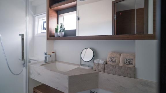 Stylish bathroom with a large mirror and high-quality towels, perfect for relaxation on Catamaran Solana.