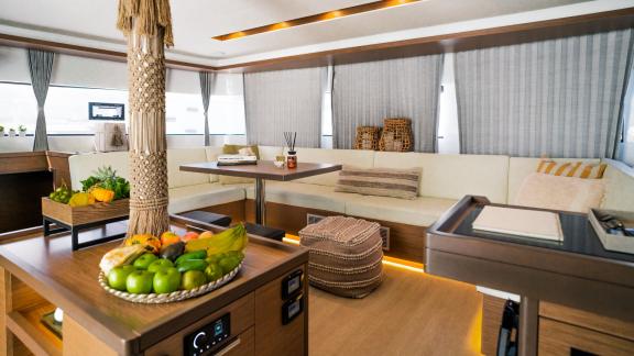 A spacious salon with cozy seating and decorative elements aboard a modern catamaran.