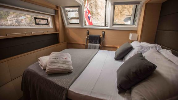 Elegant cabin on Soleanis II with large window, double bed, and fresh linens