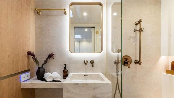 The catamaran Spice of Life offers a luxurious bathroom with gold fixtures near Athens.