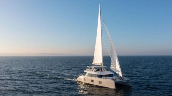The catamaran Spice of Life sails into the sunset on calm waters off Athens.