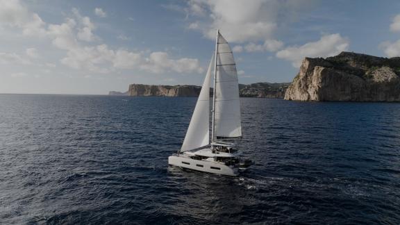 Die Lagoon 55 TriWing Carida gleitet elegant mit gesetzten Segeln durch das Meer bei Kastela.