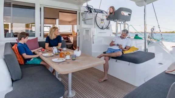 A family enjoying a relaxing breakfast on board the Lagoon catamaran, perfect for an unforgettable vacation.